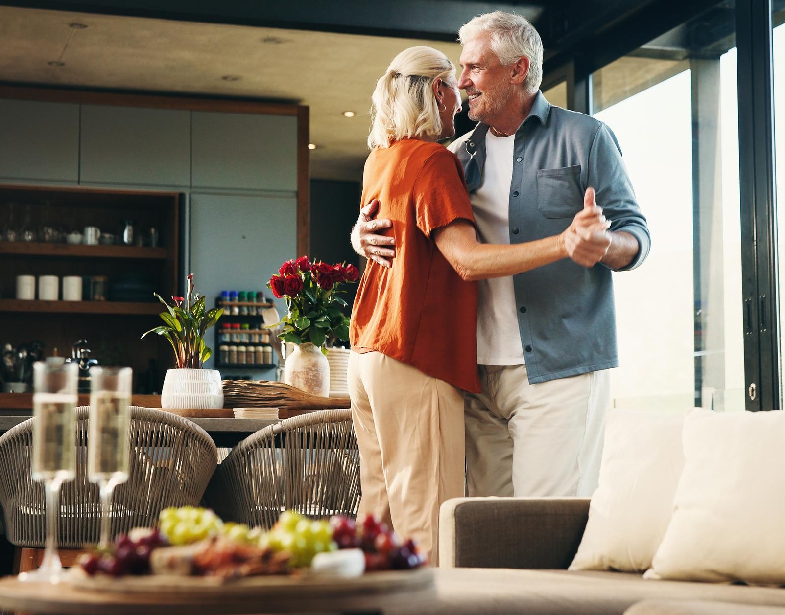 An older couple dancing together at home